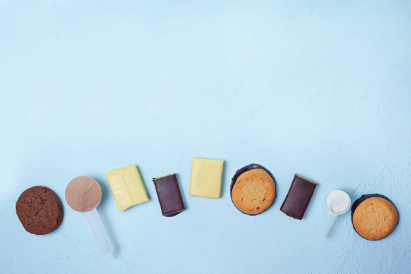 Nutrición deportiva: barras de proteína, galletas de proteína, polvo de proteína sobre un fondo azul. vista desde arriba. espacio de copia — Energía, acondicionamiento físico - Stock Photo | #245580512